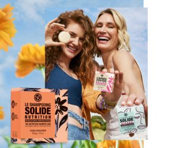 2 mulheres num campo de flores seguram em 2 produtos solidos